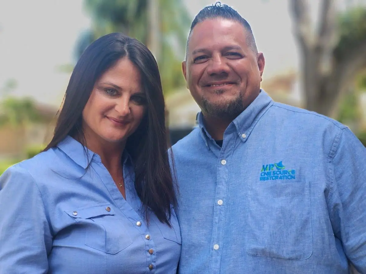 Owners Mike and Robyn Rendon standing together in MR One Source Restoration shirts
